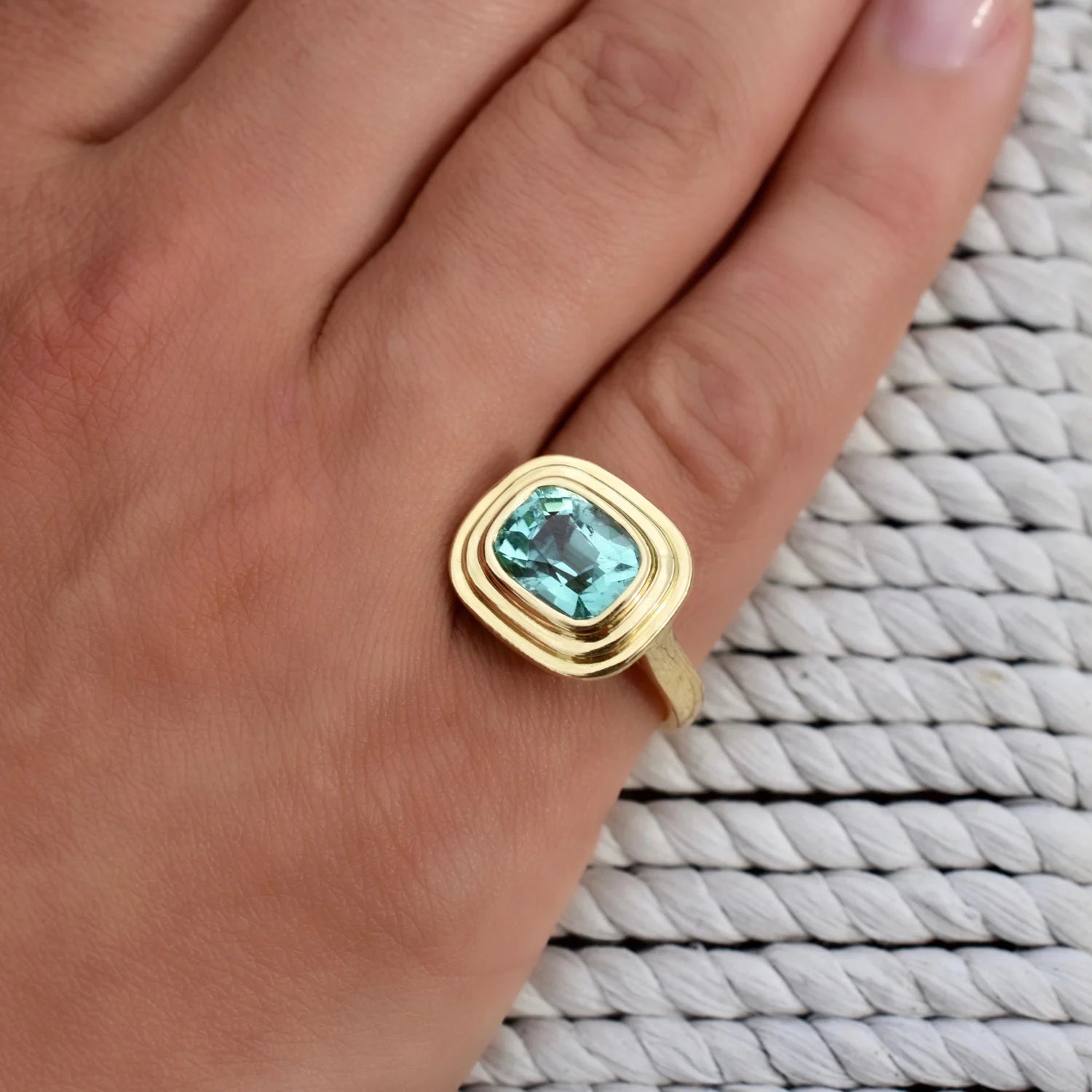 Close-up of Athena 2.70ct electric blue tourmaline ring in 18k yellow gold with cushion-cut blue tourmaline