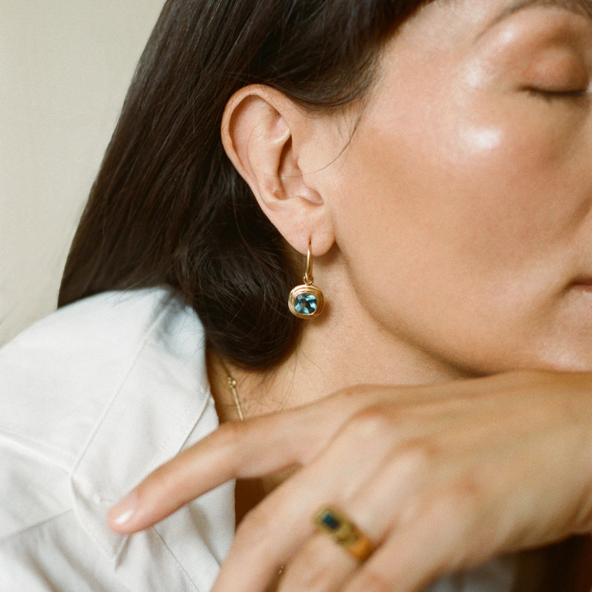 Model wearing Athena Collection mint green tourmaline drop earrings in 18k yellow gold
