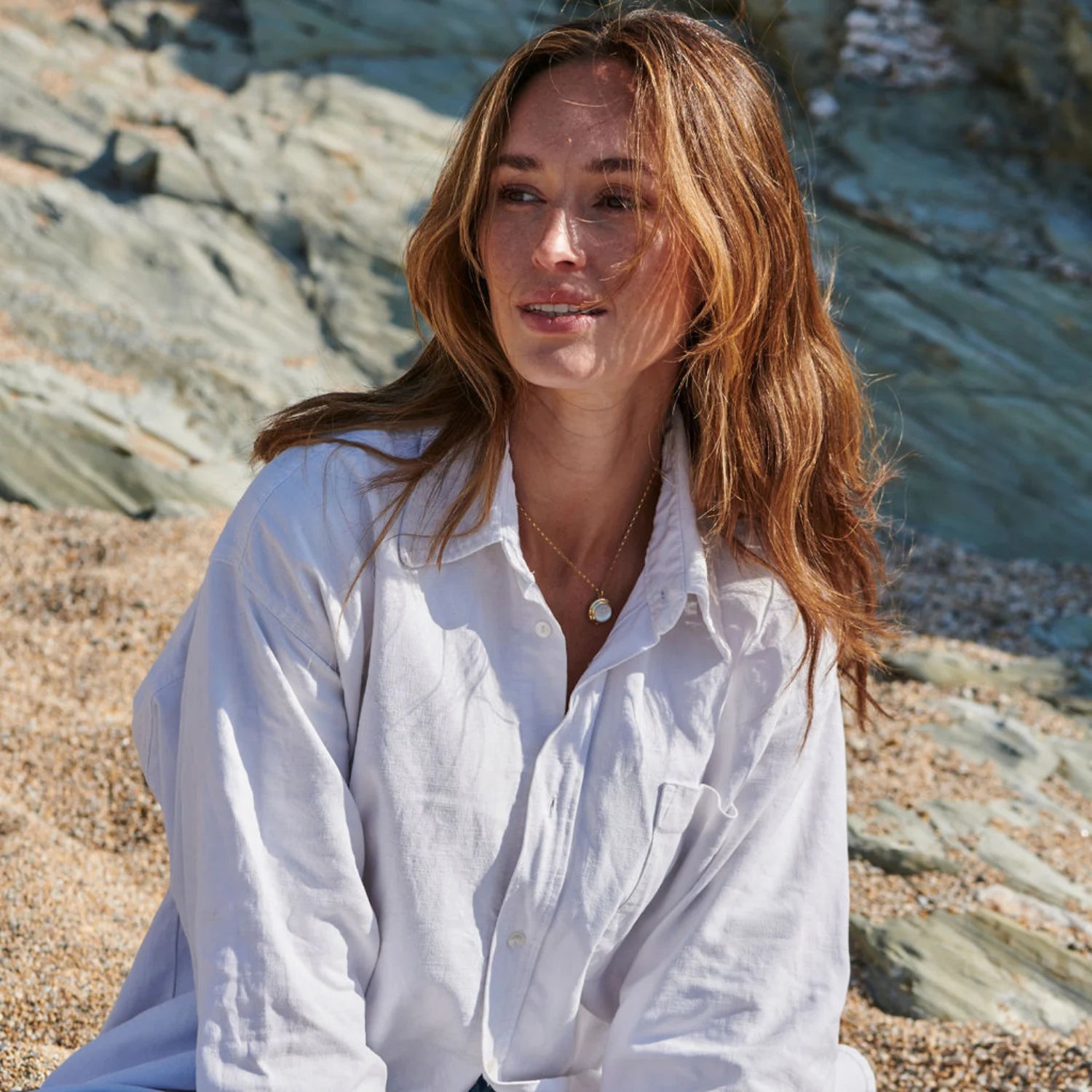 Model wearing Athena mother of pearl necklace in 14k yellow gold with iridescent mother of pearl pendant and step detailing