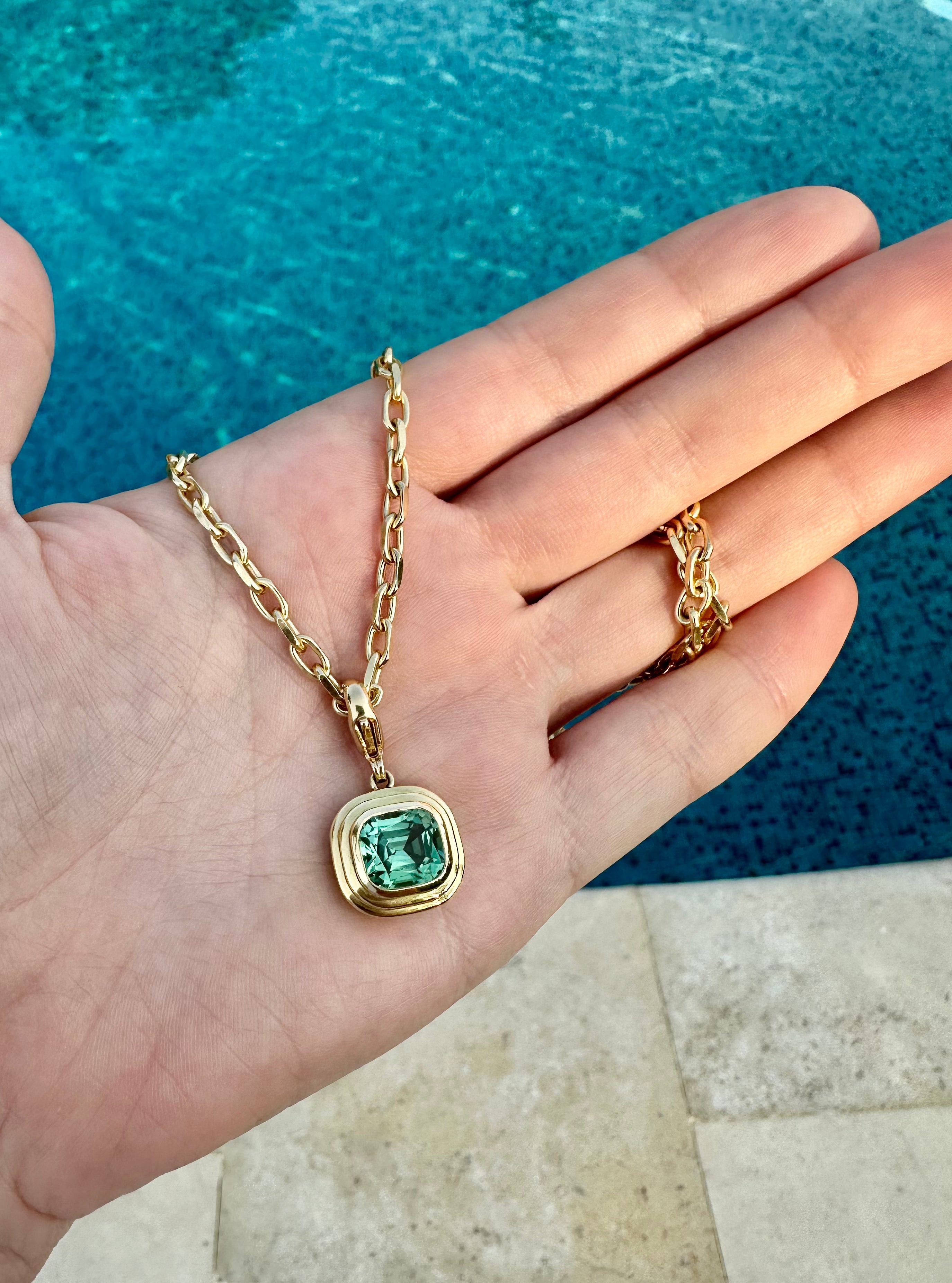 Lifestyle shot of Athena collection 18k yellow gold necklace with green Tourmaline pendant