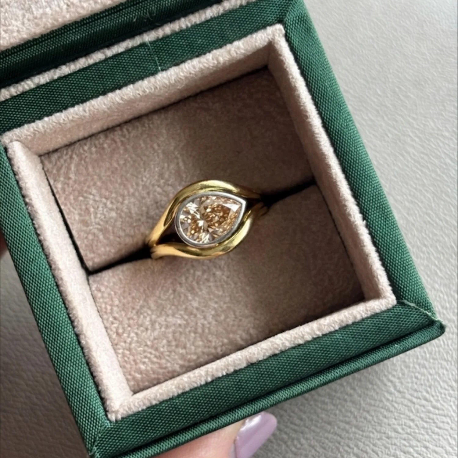 Close-up of Atlantis 2.02ct Brown Diamond Mermaid Ring in yellow and white gold with 2.02ct pear-shaped lab-grown brown diamond on mermaid tail-inspired band in minka jewels jewellery box