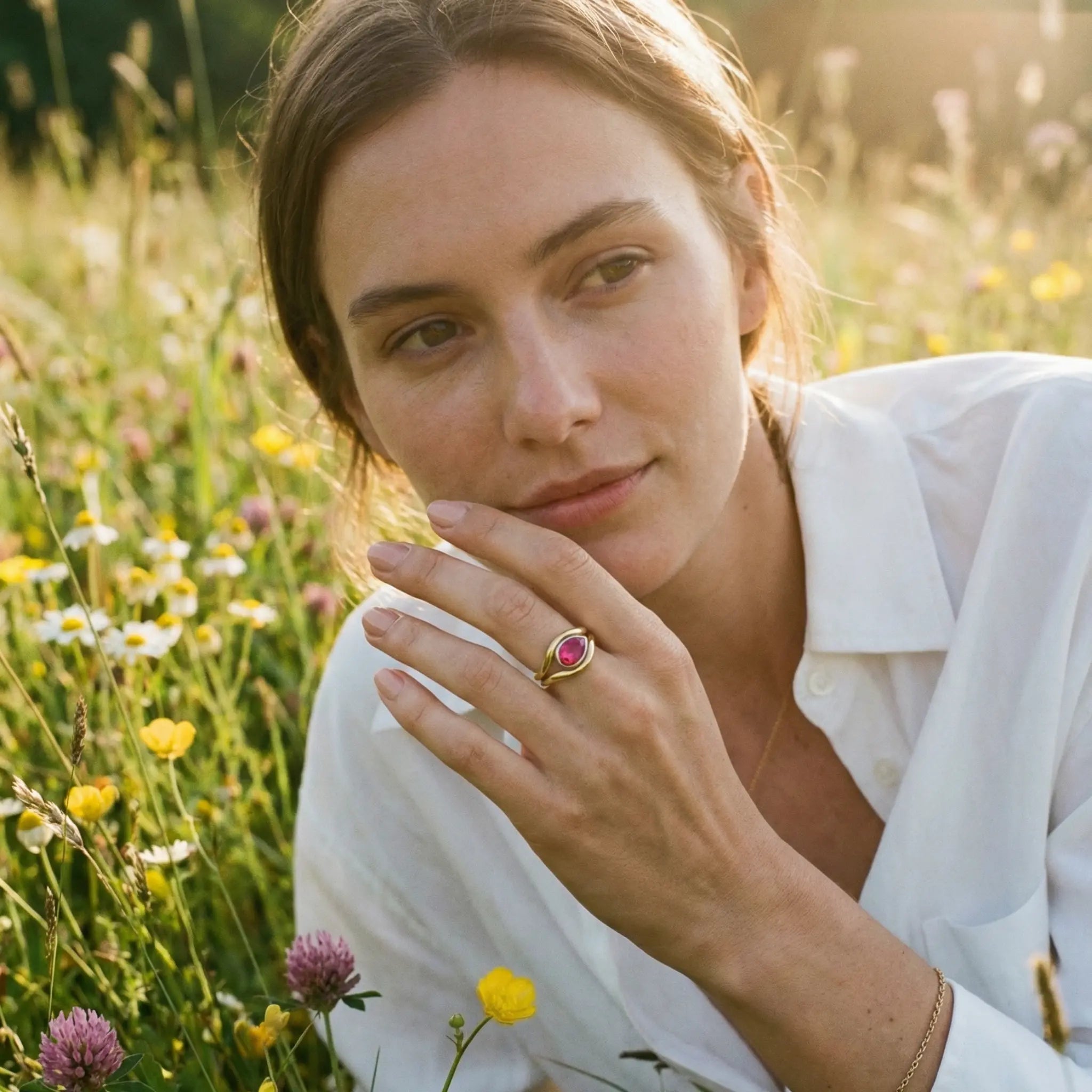 Pink tourmaline Atlantis mermaid ring on model’s hand, handcrafted in yellow and white gold with flowing curves
