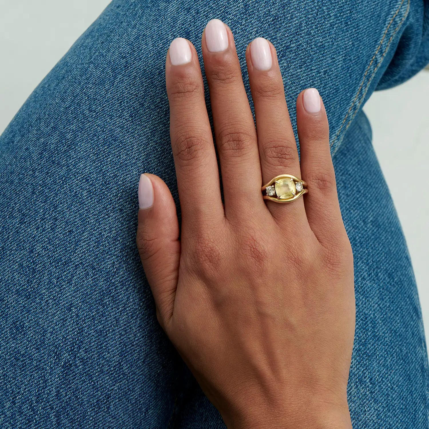 Hand model wearing Atlantis mermaid ring with 3.00ct untreated yellow sapphire and round white diamonds in 18k yellow gold