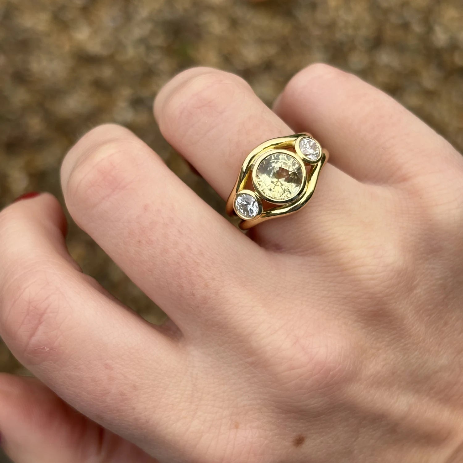 Close-up of 3.61ct untreated yellow sapphire and diamond mermaid ring in solid 18k yellow gold with round white diamonds on double-curved band