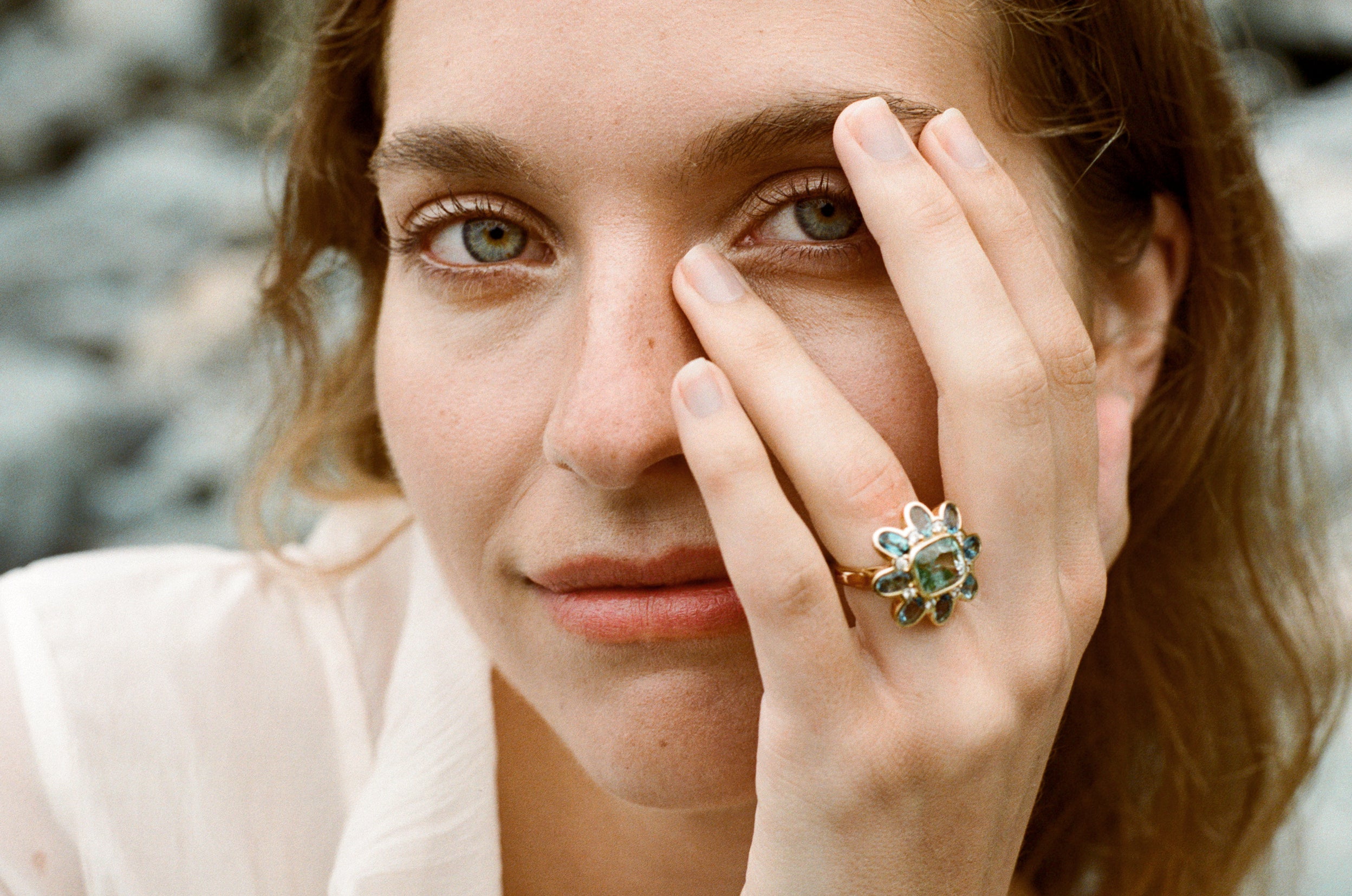 Model wearing Atlantis collection 18k yellow gold ring featuring 5.30ct green Tourmaline, 3.39ct Aquamarine, and diamonds