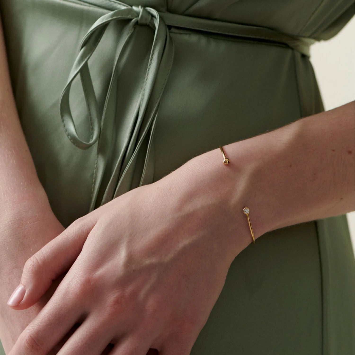 Model wearing Atlantis diamond bracelet in 18k yellow gold with white diamond and mermaid-inspired design