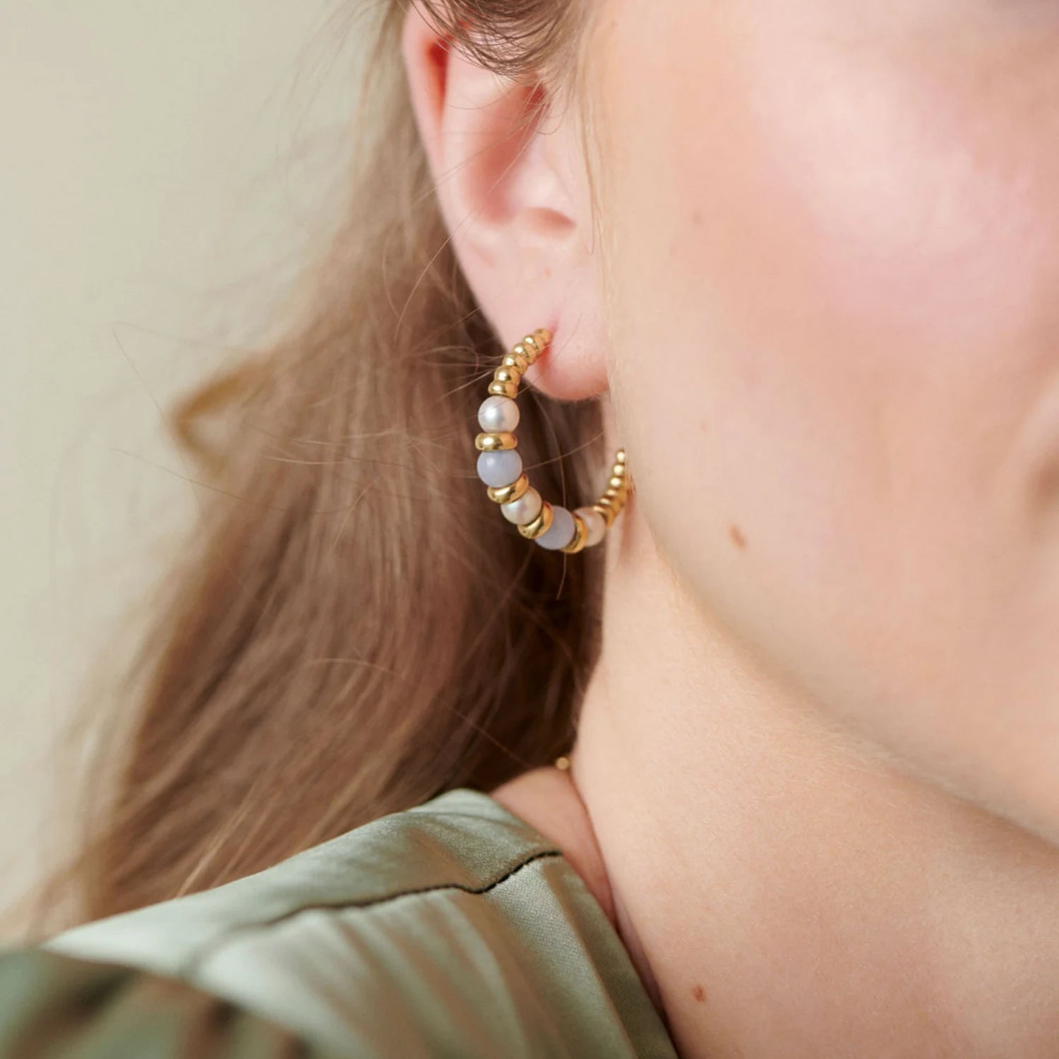 Close-up of Atlantis Small Chalcedony and Pearl Hoop Earrings in 18k yellow gold with pale blue chalcedony beads and white freshwater pearls