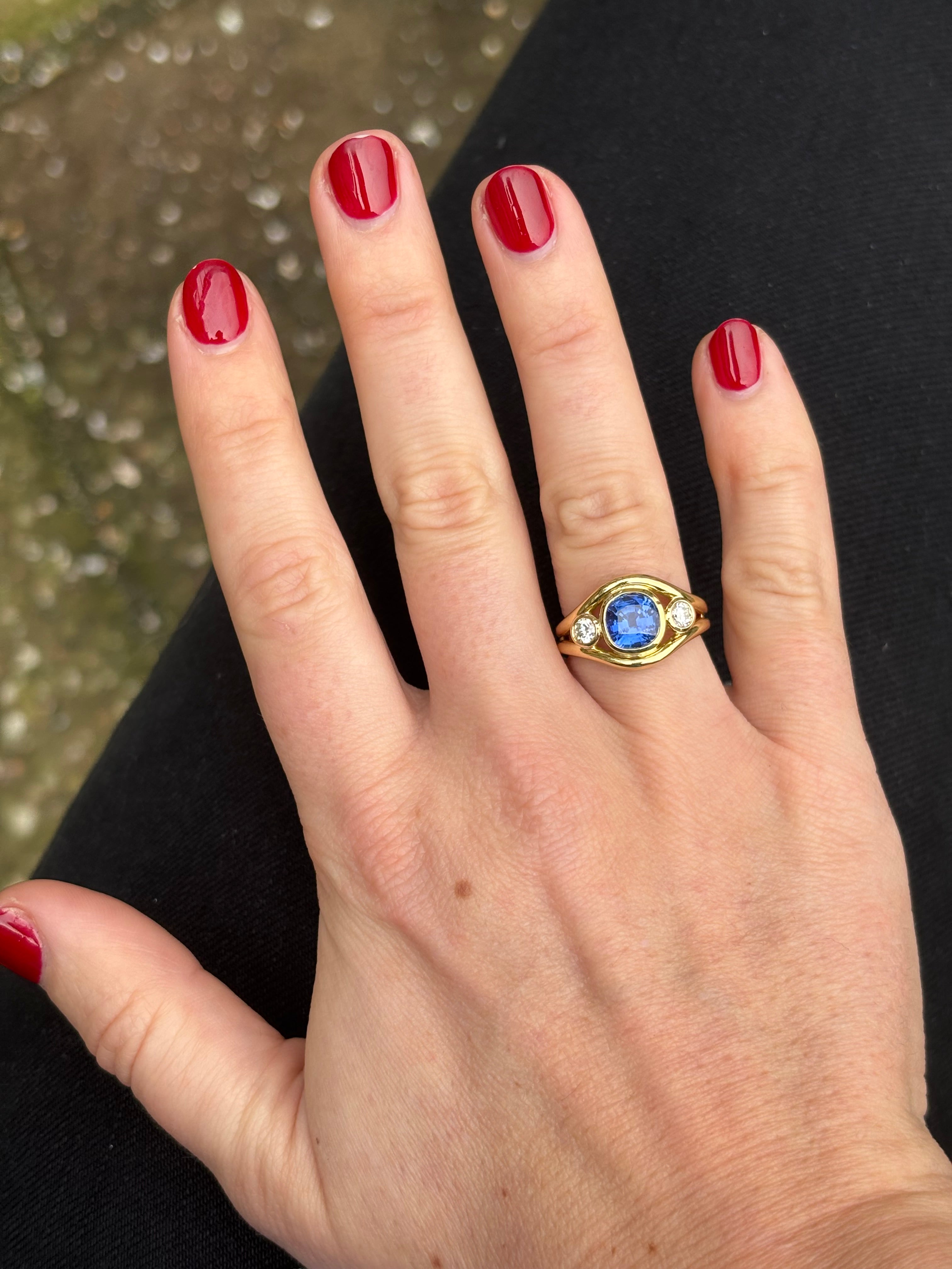 Close-up of blue sapphire and diamond Atlantis ring showing mermaid-inspired double curved band