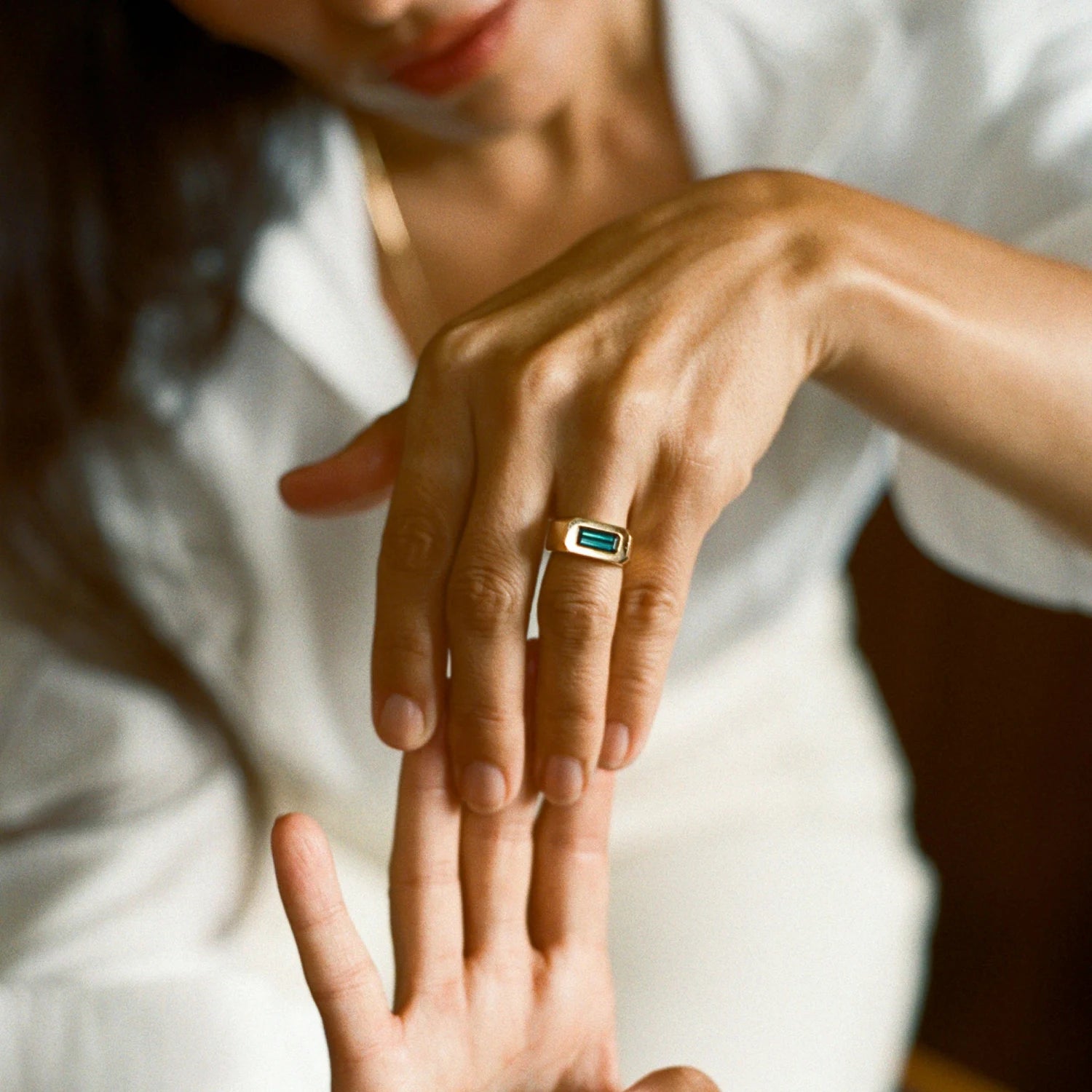 Model wearing teal tourmaline gypsy ring, 18k gold with 1.50ct deep-set tourmaline, bold gender-neutral style.