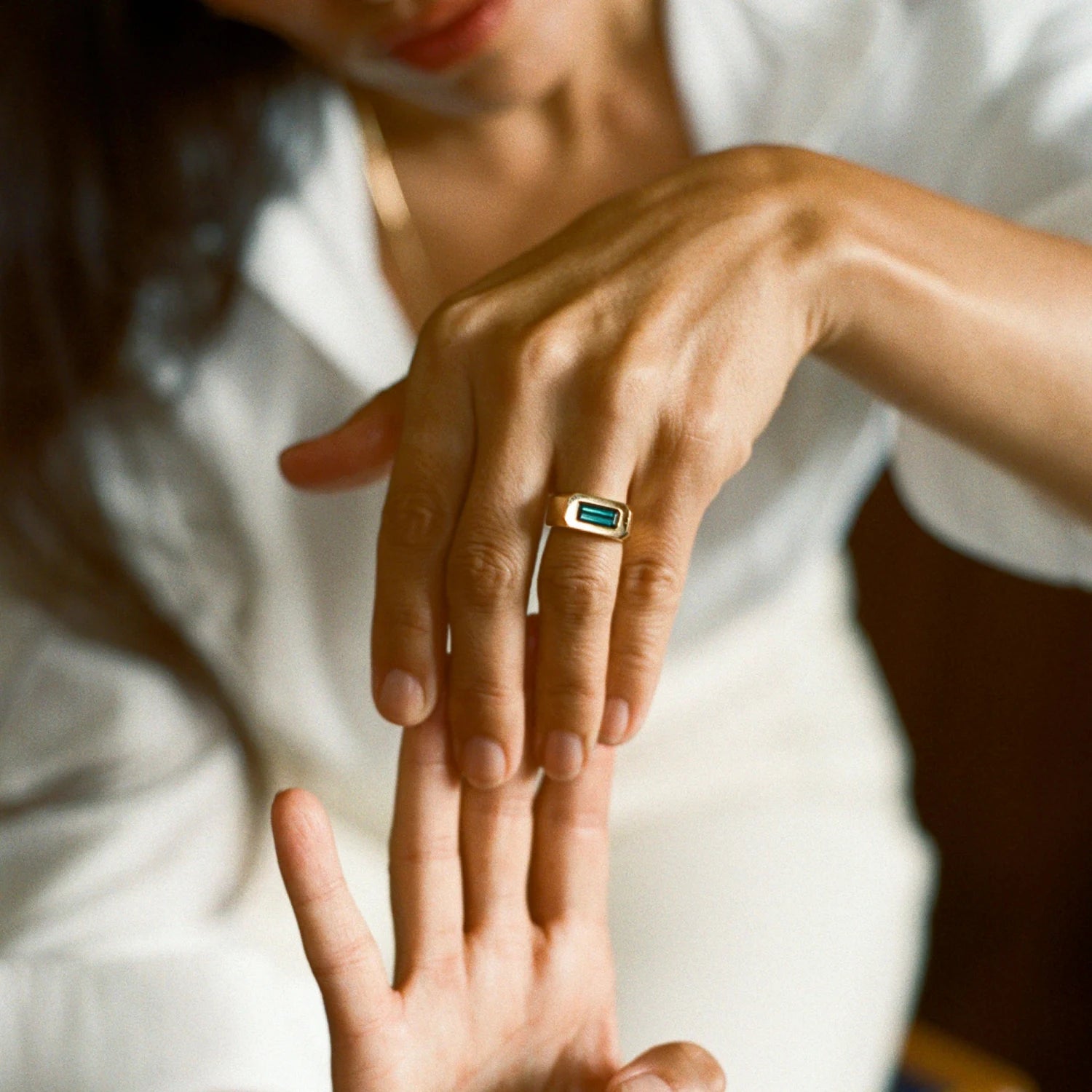 Model wearing teal tourmaline gypsy ring, 18k gold with 1.50ct deep-set tourmaline, bold gender-neutral style.
