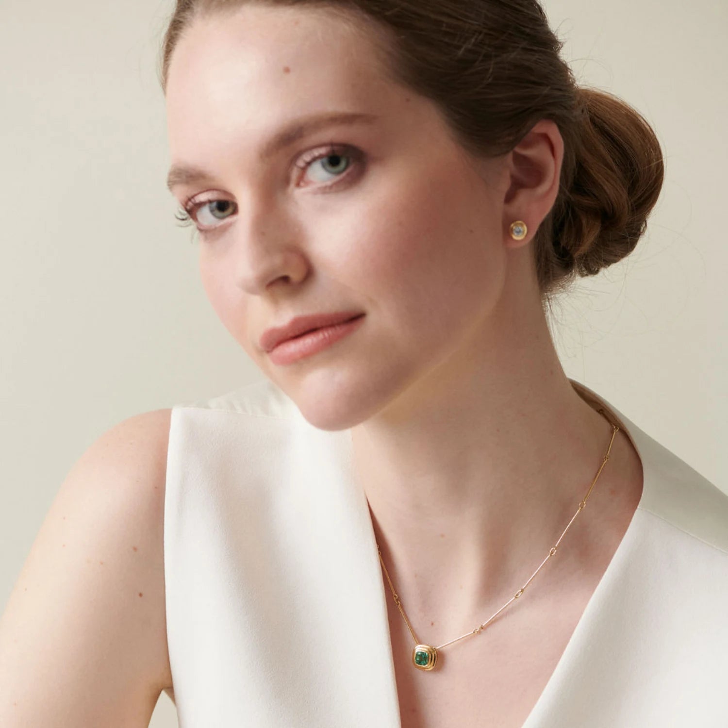 Model wearing Berlin Nights Blue Sapphire Necklace, 18k gold with 2.10ct square octagonal-cut sapphire and diamond halo pendant.