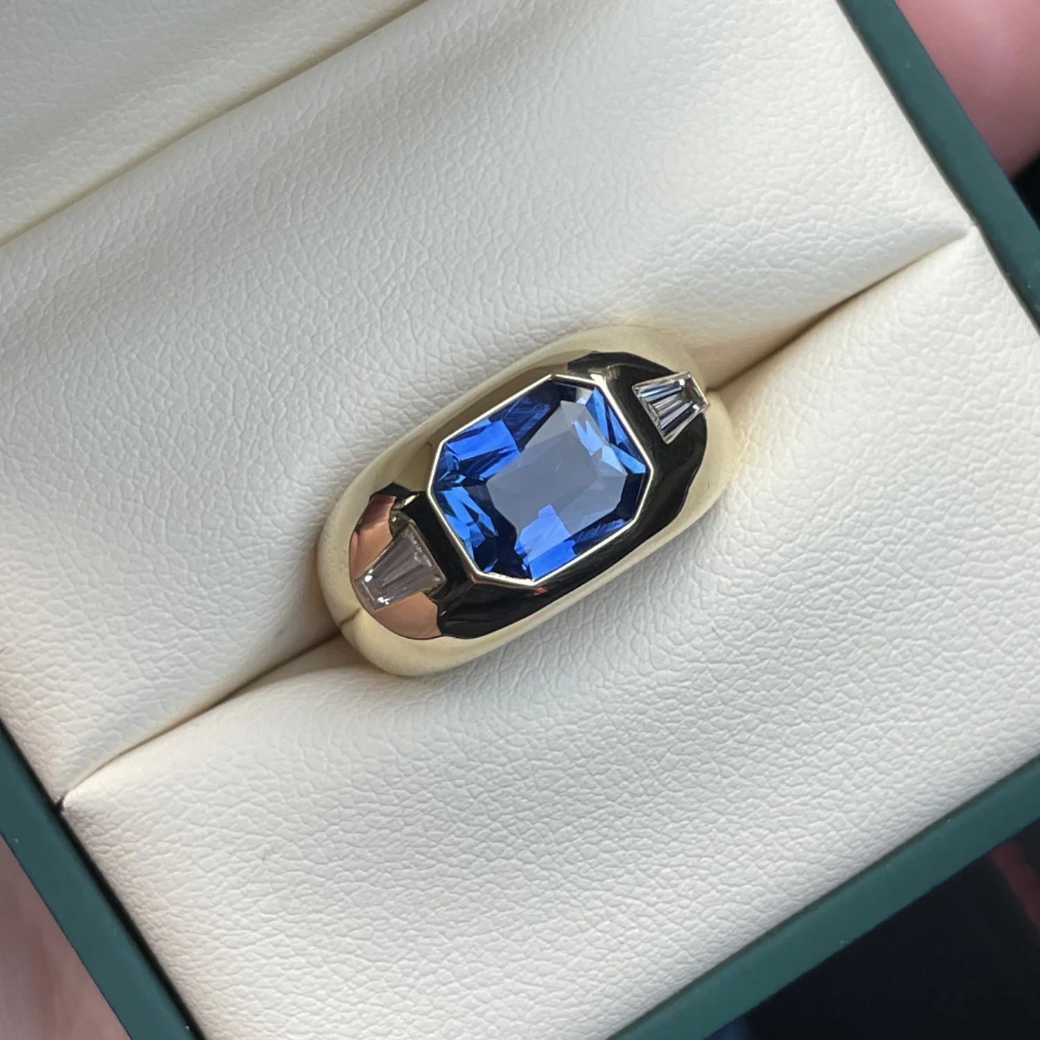 Close-up of Berlin Gypsy Sapphire Ring showing 3.16ct emerald-cut no heat sapphire and 0.40ct baguette diamonds in 18k gold.