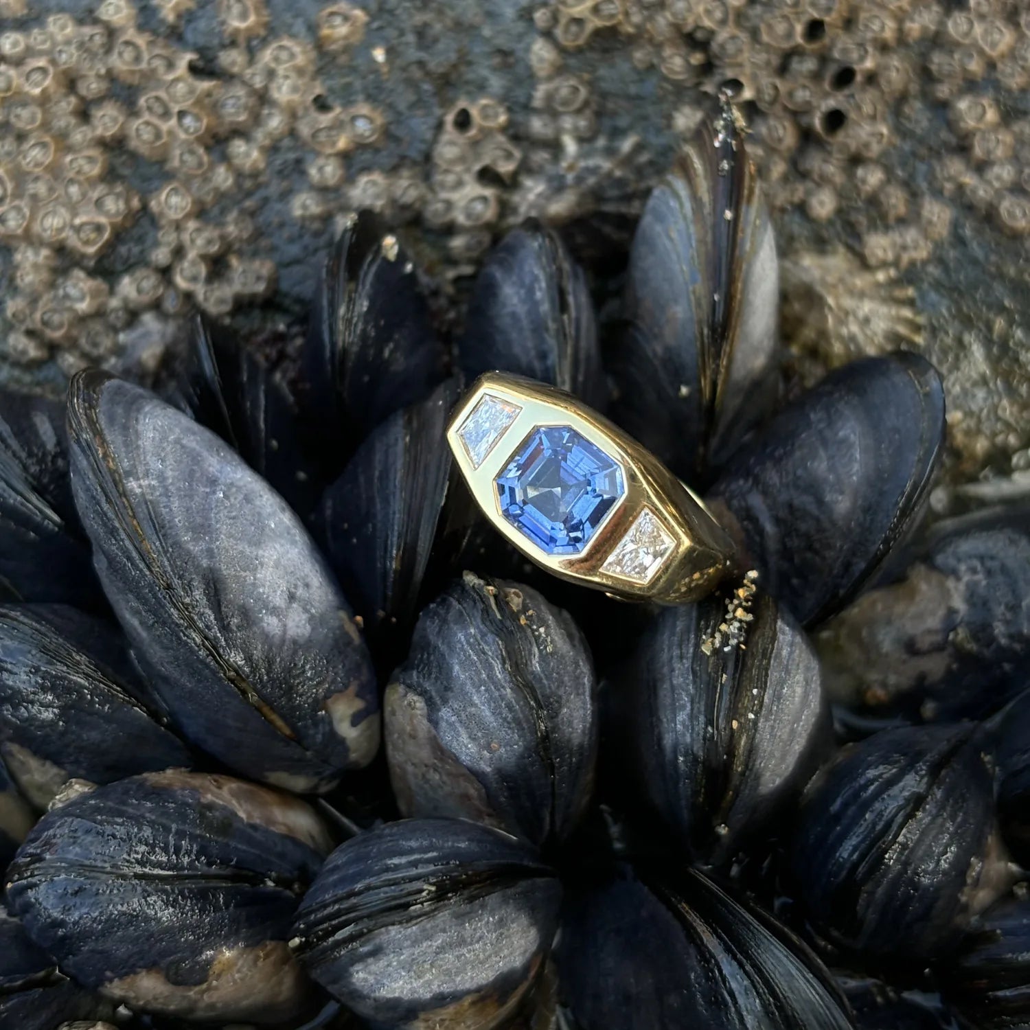 Close-up of octagon sapphire ring showing 2.54ct blue sapphire and 0.50ct trapezoid-cut white diamonds in 18k yellow gold