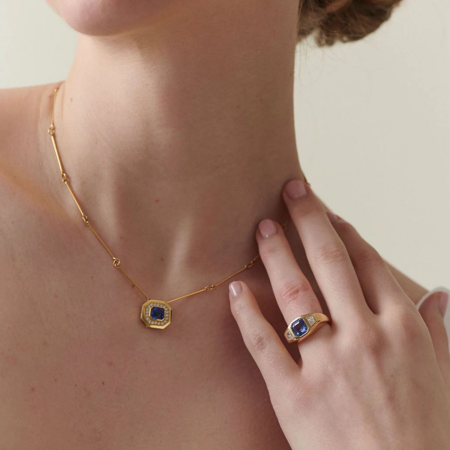 Model wearing 18k yellow gold engagement ring with 2.54ct octagon sapphire and trapezoid diamonds, styled with other statement diamond pieces of Minka Jewels