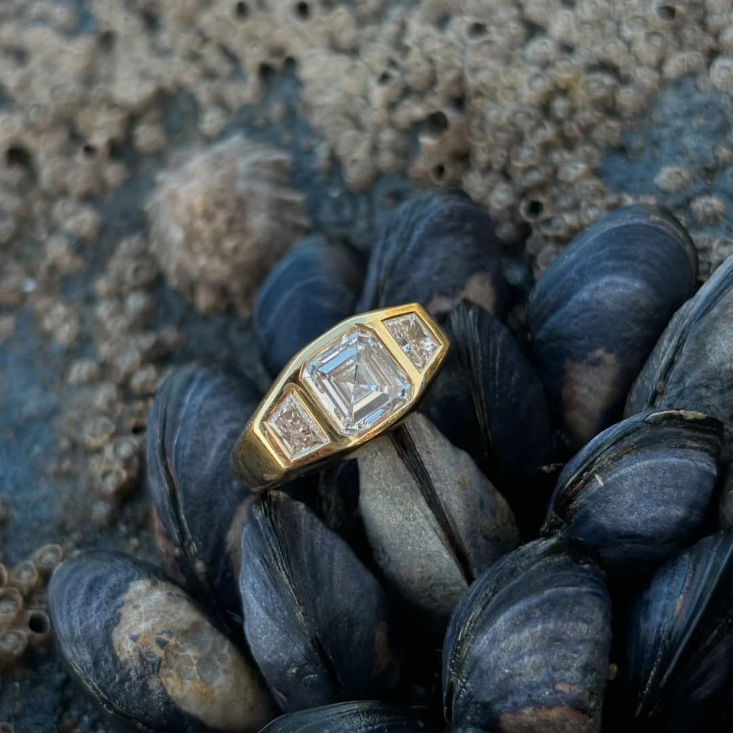 Close-up of Asscher-cut diamond ring showing 2ct octagon diamond and 0.50ct trapezoid-cut white diamonds in 18k yellow gold