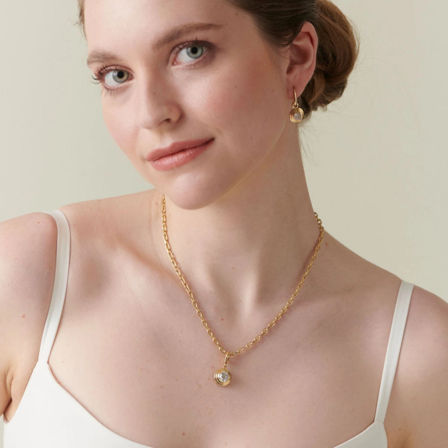 Model wearing Athena 2ct old cut diamond necklace in 18k yellow gold with cushion-cut diamond on chunky chain paired with matching diamond earrings