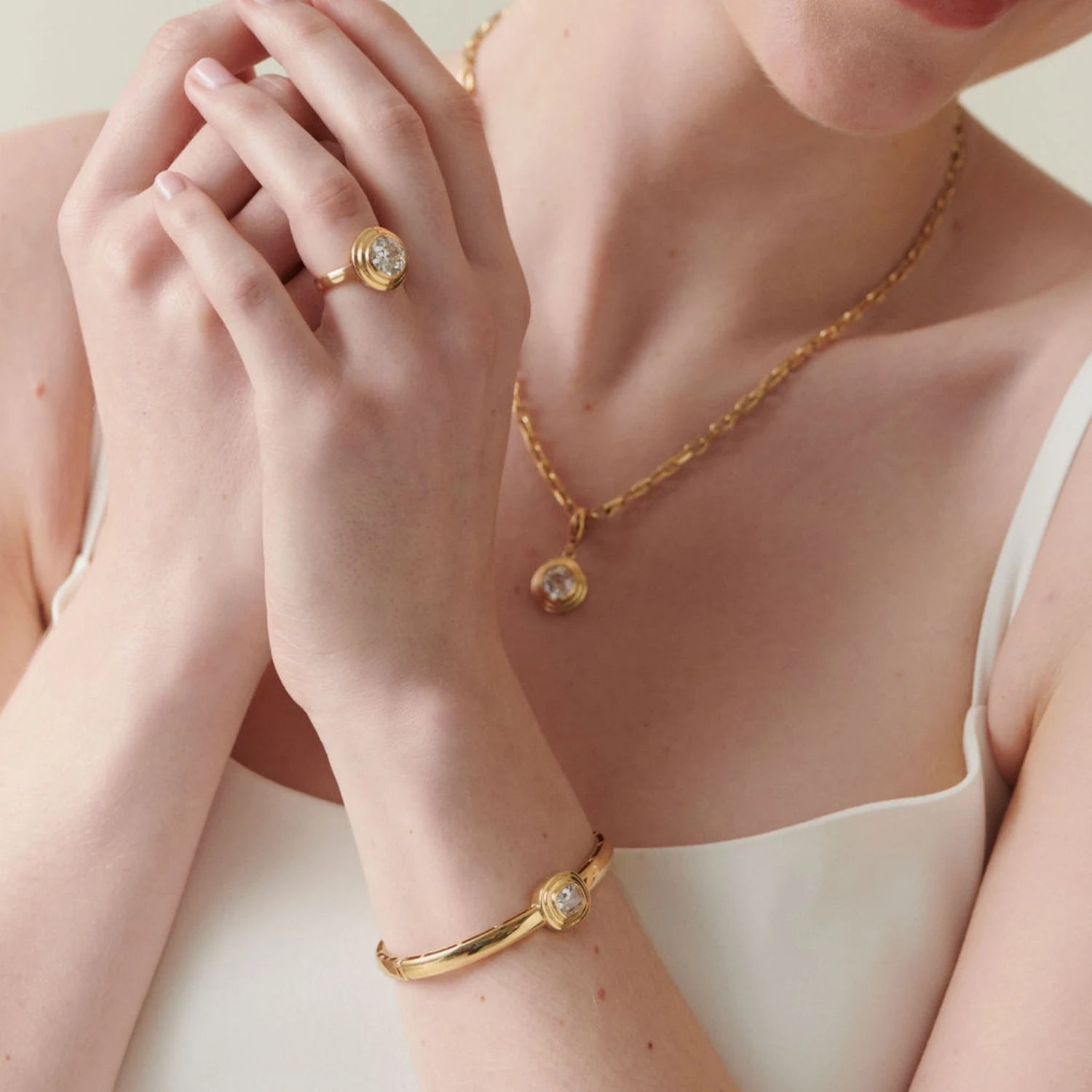 Model wearing 1.16ct Old Cut Cushion Diamond bangle in 18k yellow gold, paired with matching pieces from the Athena Bridal collection