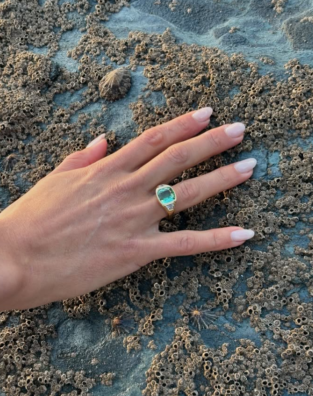 Model wearing 18k yellow gold bridal ring with 5ct green Tourmaline and trapezoid diamonds