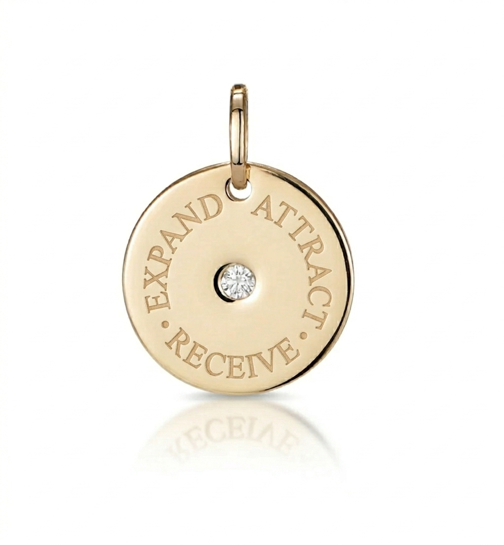 Front view of 15mm engraved mantra disc pendant with central diamond and three-word Attract, Receive, Expand, oval jump ring for easy chain attachment