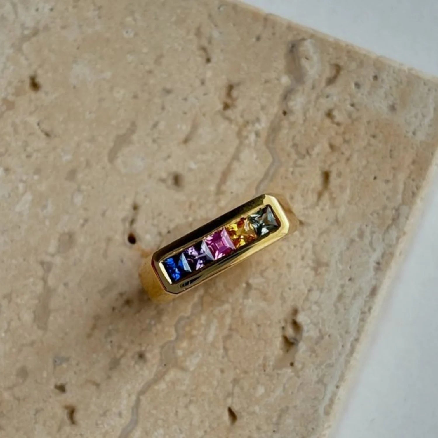 Close-up of Ley Lines Rainbow Sapphire Pinky Ring showing five princess-cut rainbow sapphires in 18k yellow gold band