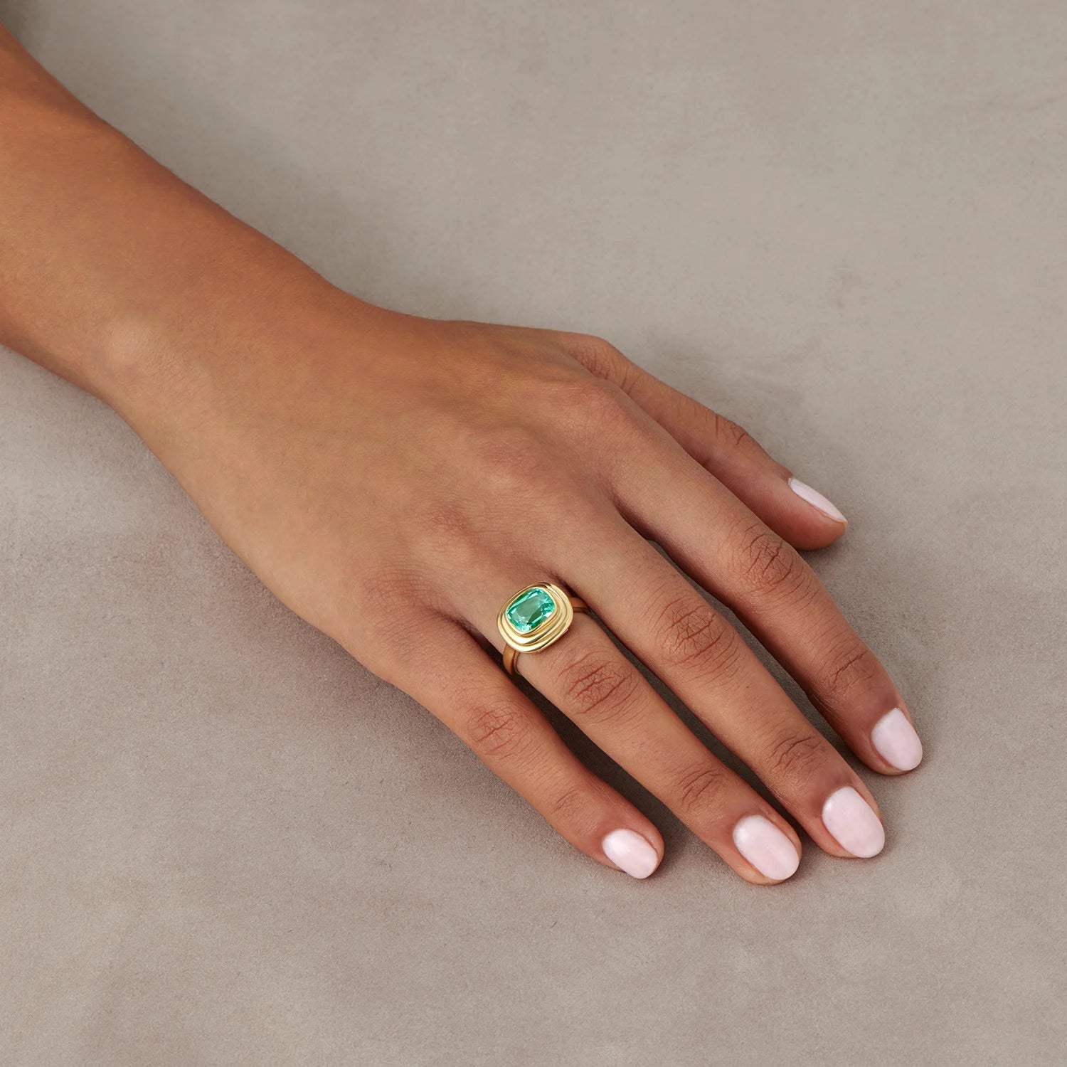 Hand model wearing Athena 2.70ct electric blue tourmaline ring in 18k yellow gold with cushion-cut blue tourmaline