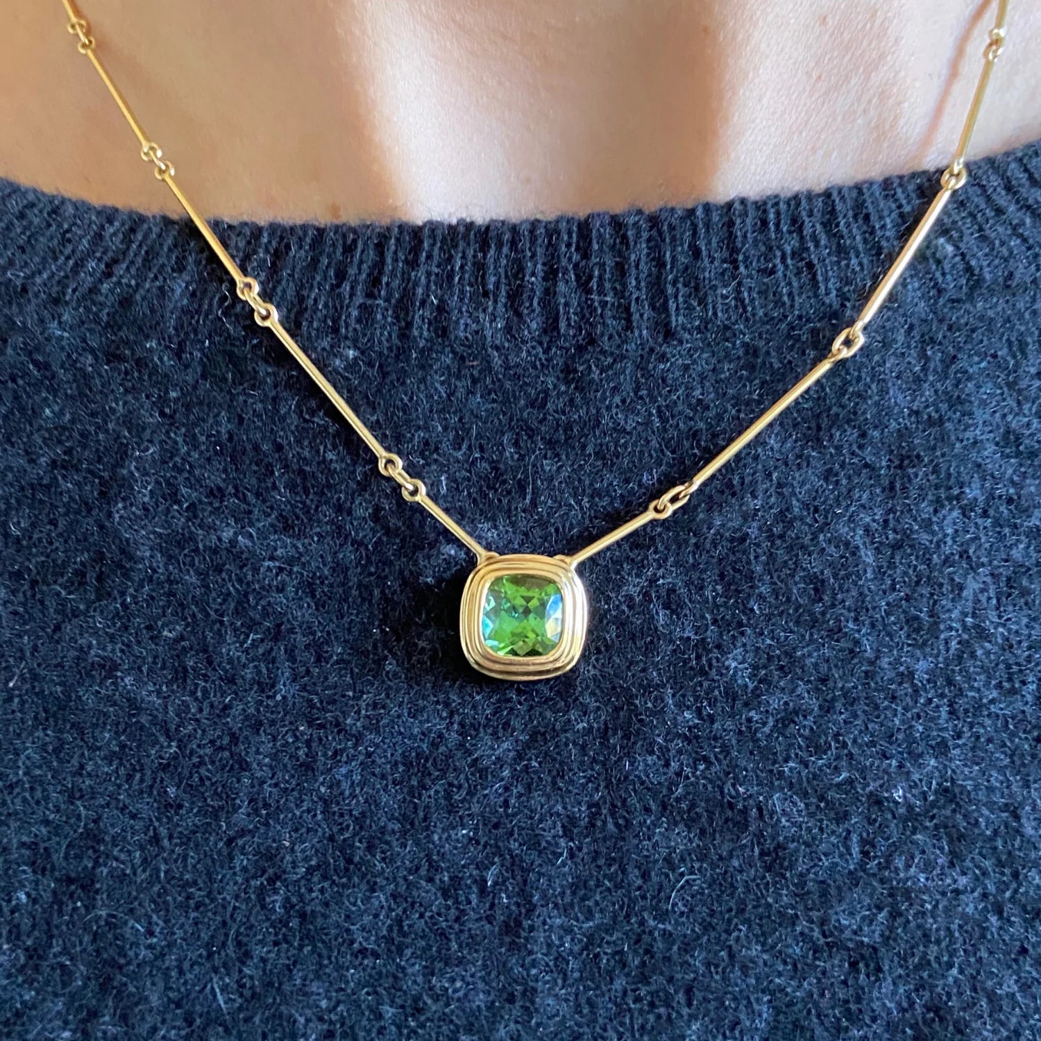 Close-up of Athena 3ct green tourmaline necklace in 18k yellow gold with cushion-cut green tourmaline