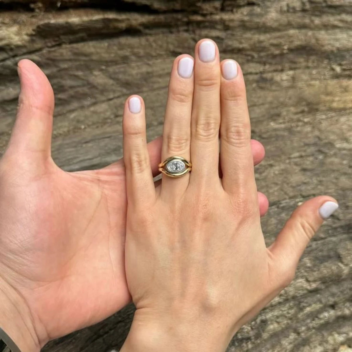 Hand wearing Atlantis 2ct Diamond Mermaid Ring in yellow and white gold with 2ct oval-shaped white diamond on mermaid tail-inspired band