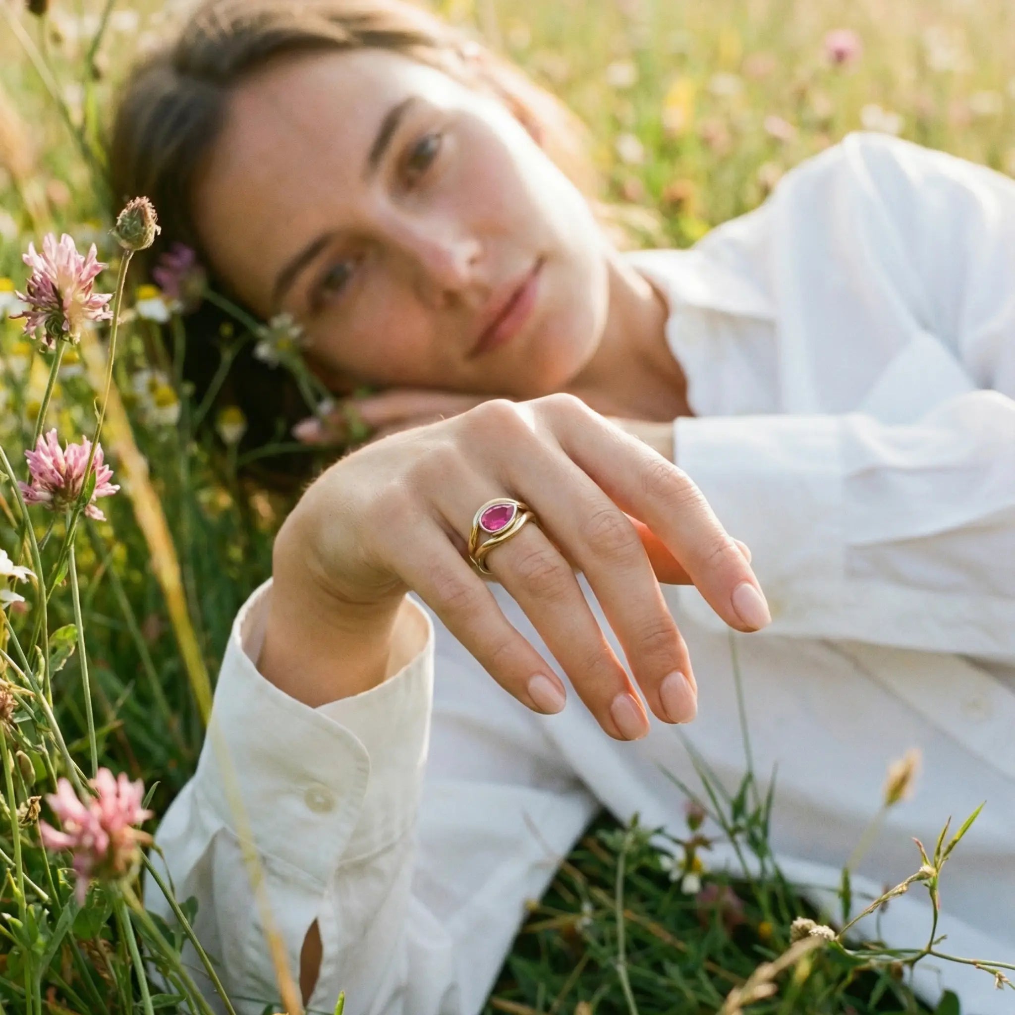 Pink tourmaline Atlantis mermaid ring on model’s hand, handcrafted in yellow and white gold with flowing curves