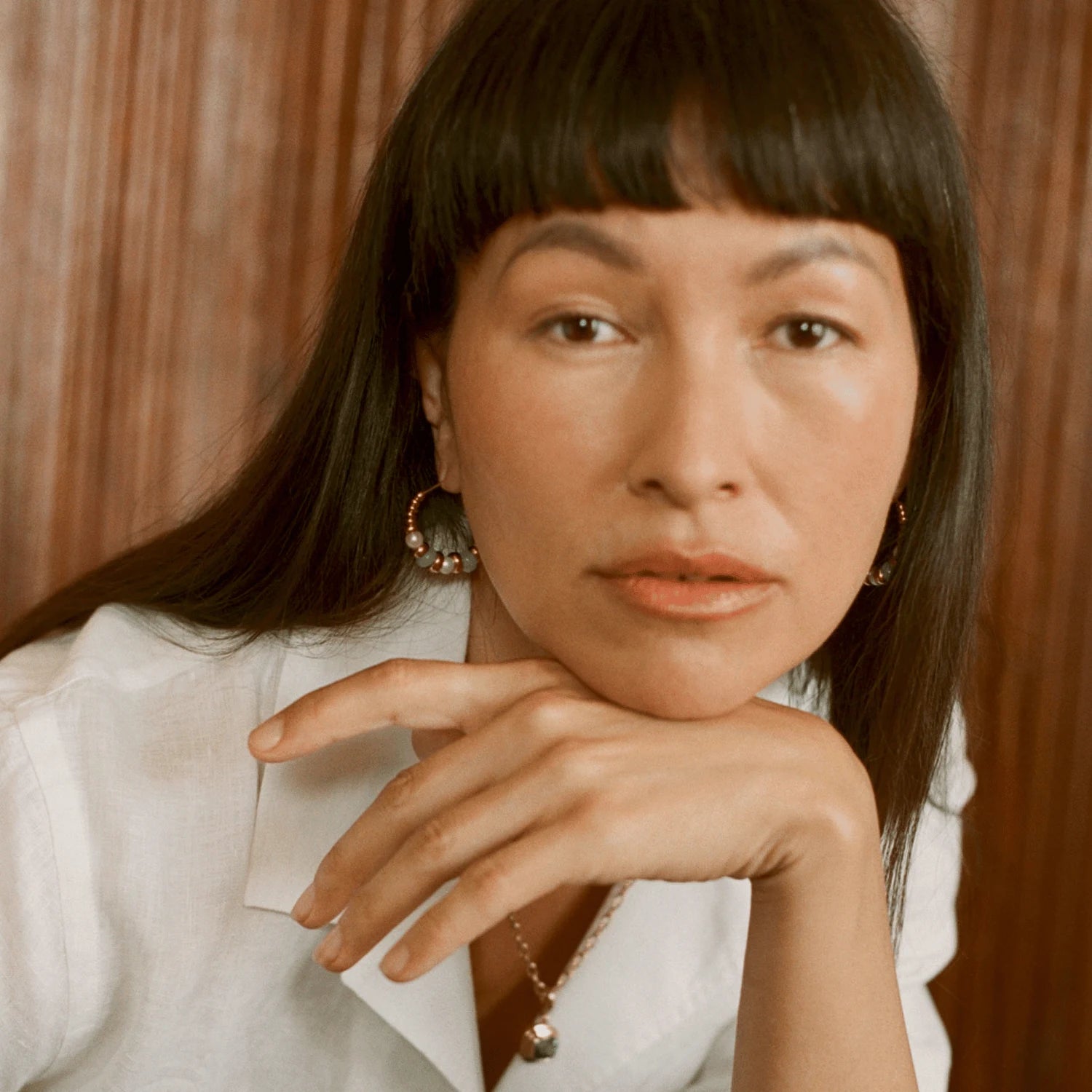 Model wearing Atlantis chrysoprase and pearl hoop earrings in 18k yellow gold with green chrysoprase beads and white freshwater pearls