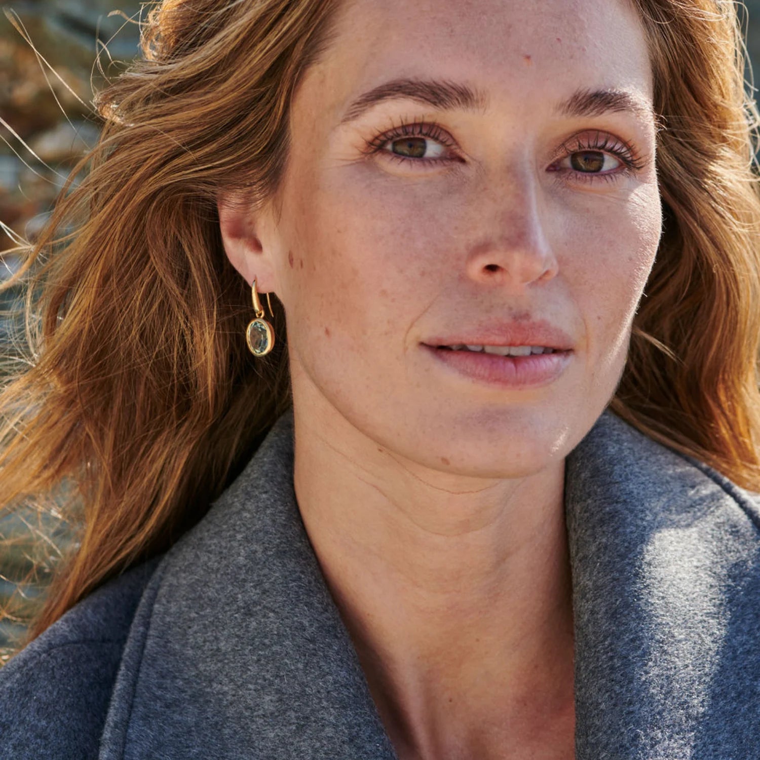 Model wearing green amethyst drop earrings in 18k yellow gold with luminous 12 x 10mm gemstones