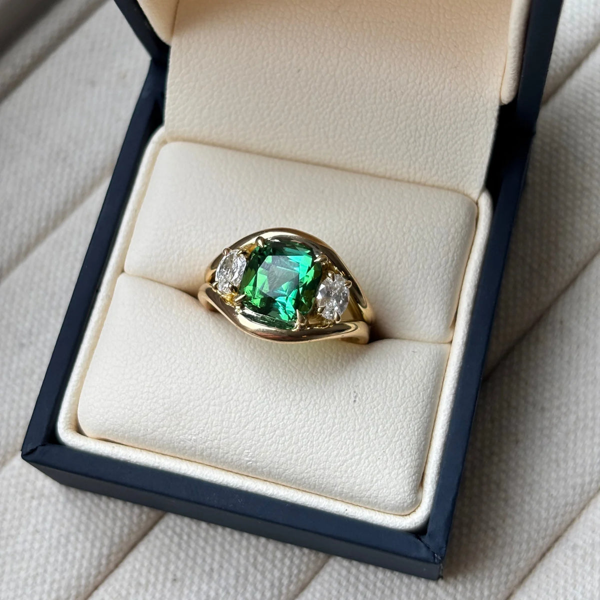 Close-up of Atlantis green tourmaline mermaid ring in 18k yellow gold with square cushion-cut tourmaline and round white diamonds