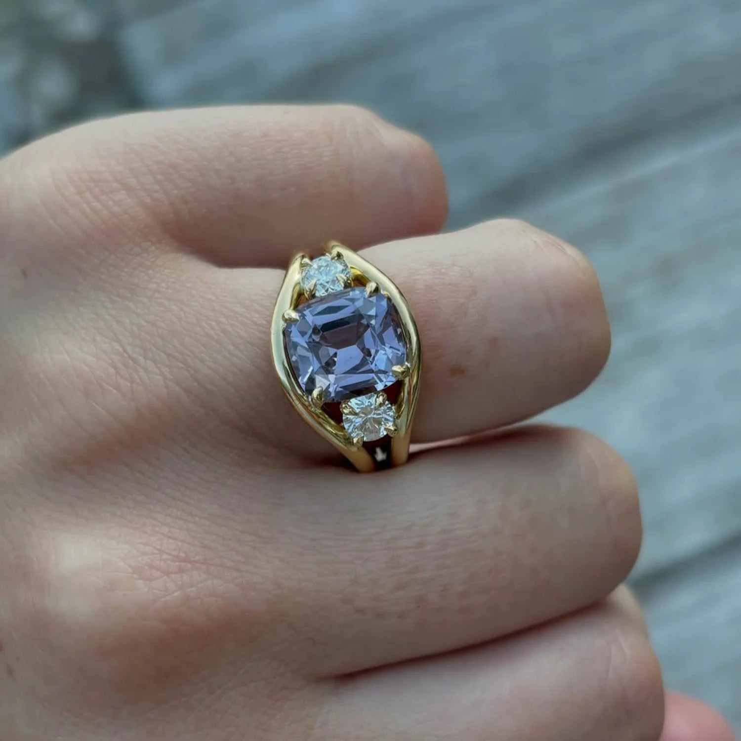 Close-up of Atlantis 3.62ct Lilac Spinel and Diamond Ring in solid 18k yellow gold with vivid lilac spinel and round white diamonds on mermaid-inspired band