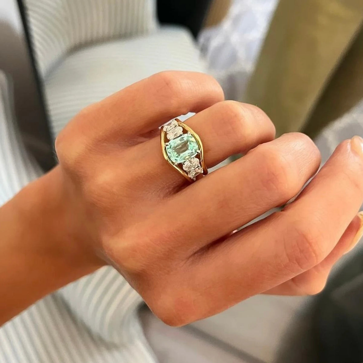 Close-up of Atlantis pale blue green tourmaline mermaid ring in 18k yellow gold with square cushion-cut tourmaline and 4 oval white diamonds