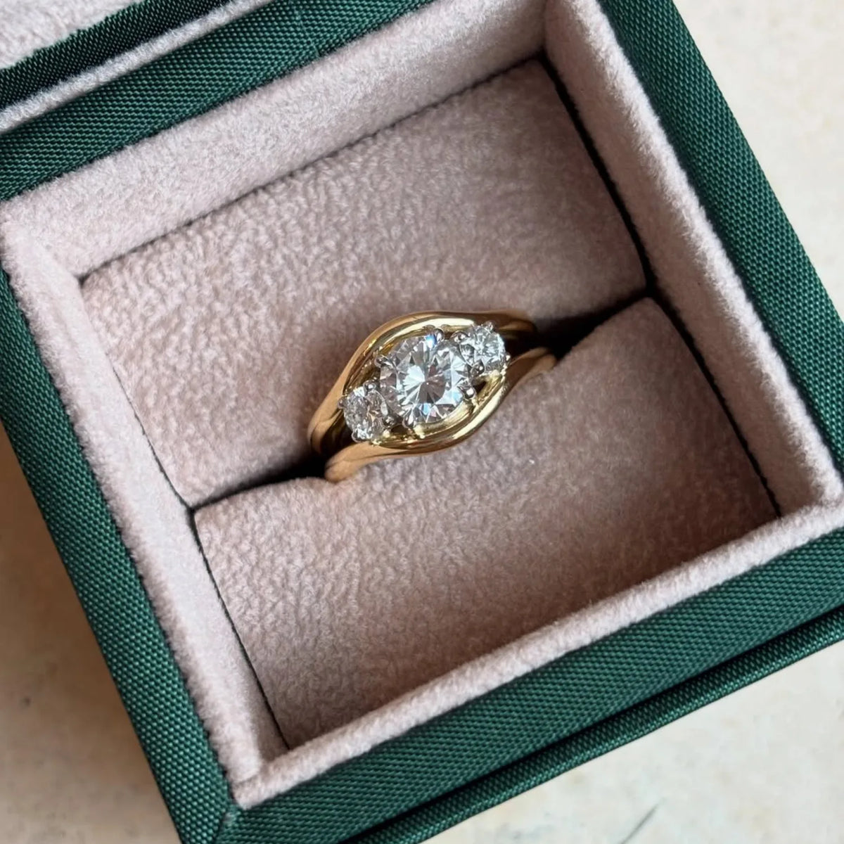 Close-up of Atlantis in 18k yellow gold mermaid band with trio round white diamonds