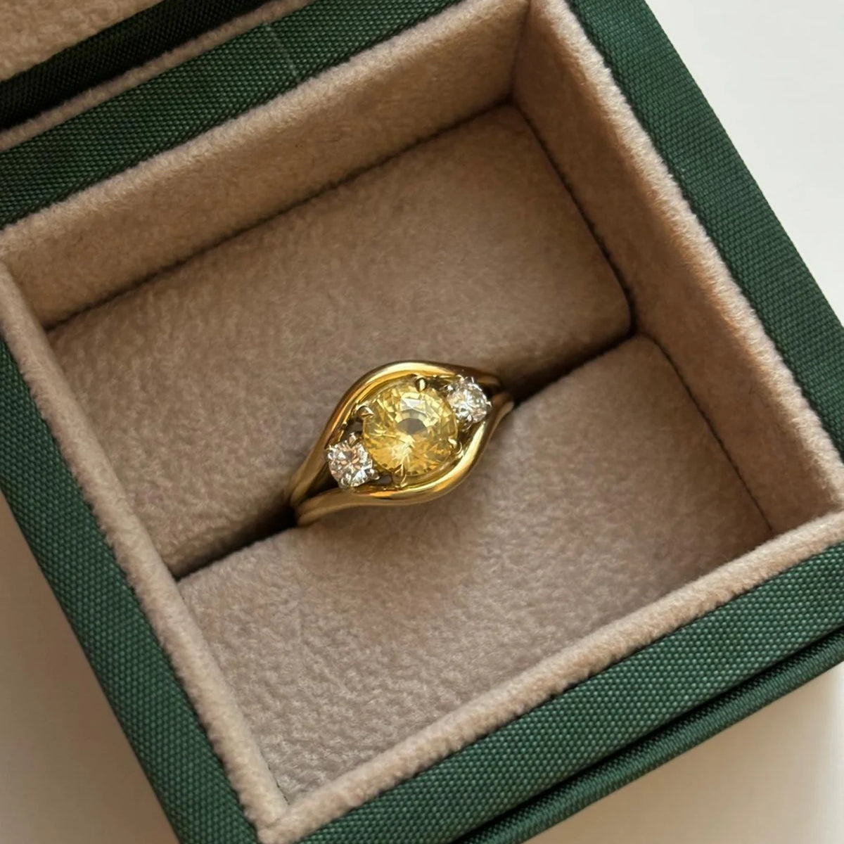 Close-up of Atlantis vibrant yellow sapphire mermaid ring in 18k yellow gold with round-cut yellow sapphire and round white diamonds