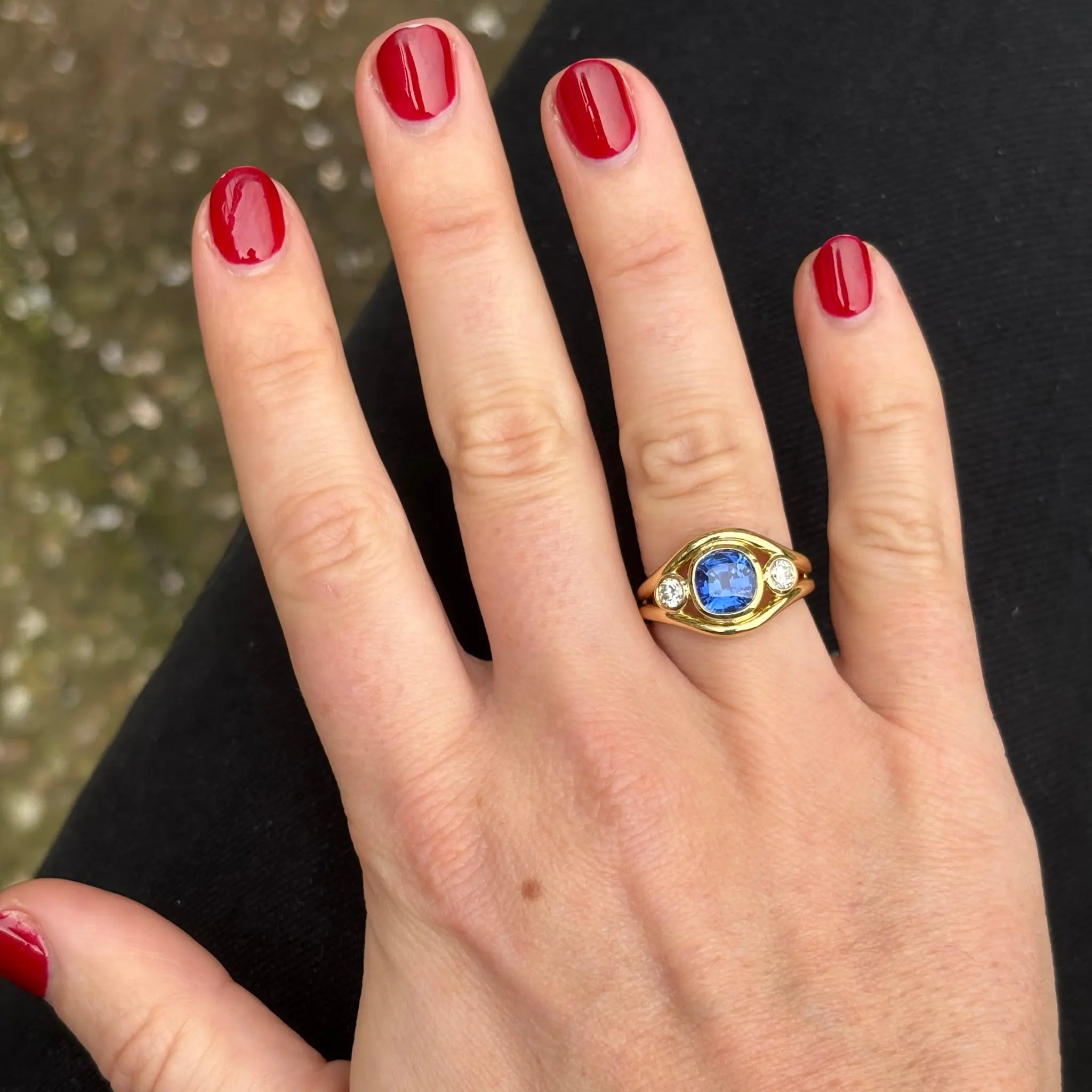 Close-up of blue sapphire and diamond Atlantis ring showing mermaid-inspired double curved band
