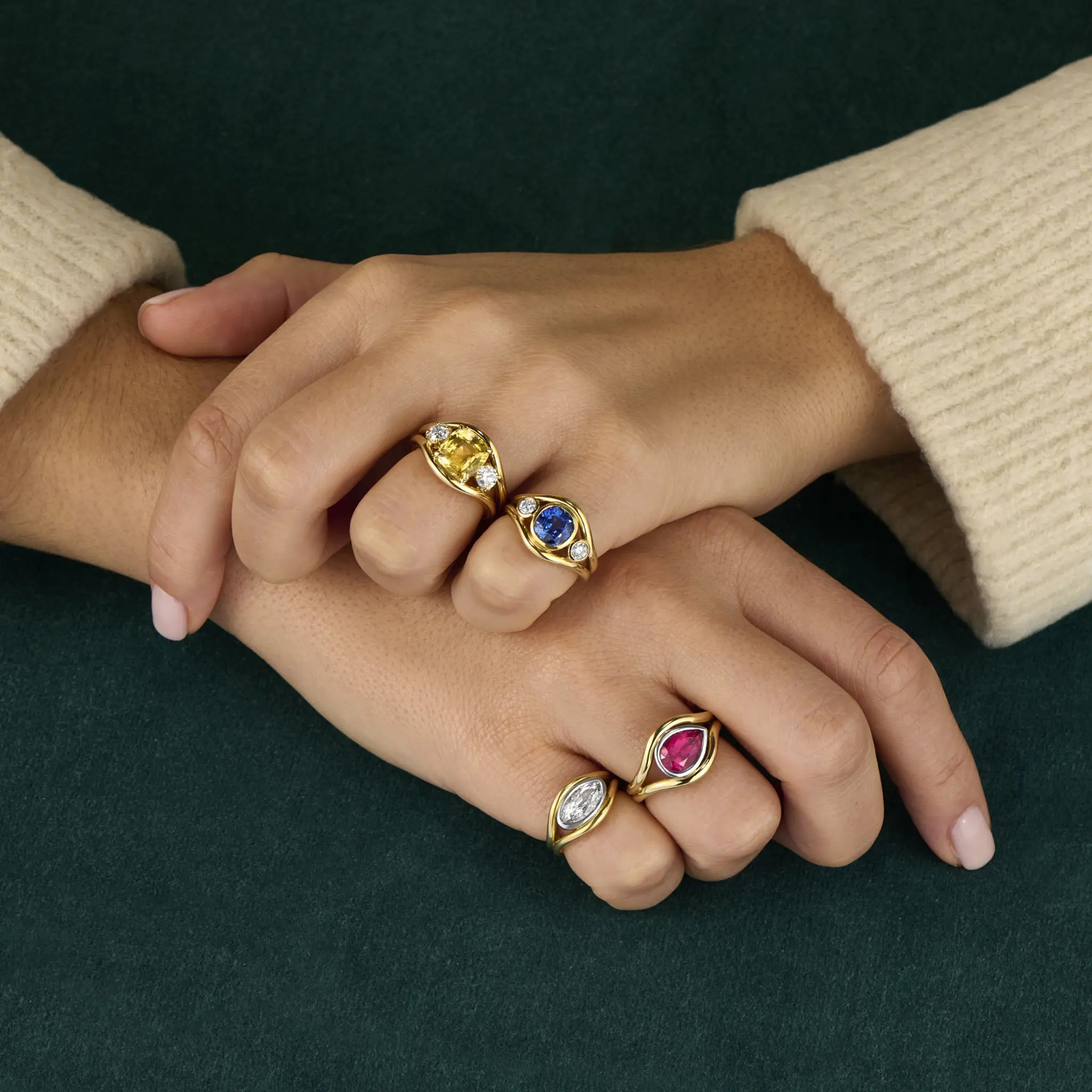 Atlantis collection mermaid rings on model’s hand, handcrafted in yellow and white gold with flowing mermaid-inspired curves