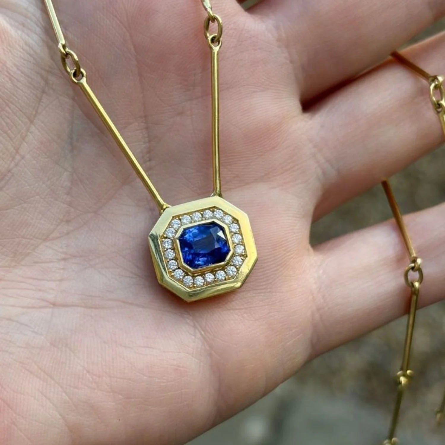 Close-up of Berlin Nights Blue Sapphire Necklace, 2.10ct square octagonal-cut sapphire with 0.30ct diamond halo in 18k gold.