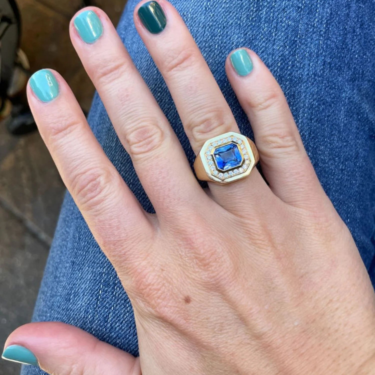 Hand model wearing Berlin Nights Blue Sapphire Ring, 18k gold with 2.91ct square octagonal-cut sapphire and diamond halo.