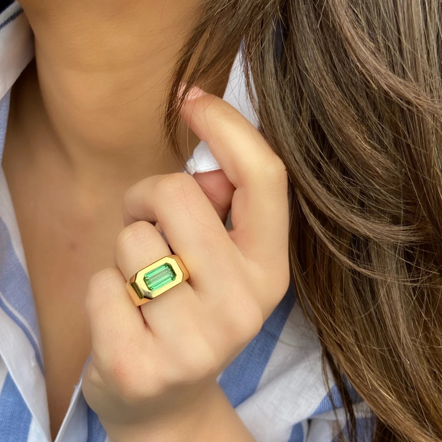 Model wearing Berlin Cocktail Ring, 18k gold with 3ct octagonal-cut blue/green tourmaline, bold Bauhaus-inspired unisex design.