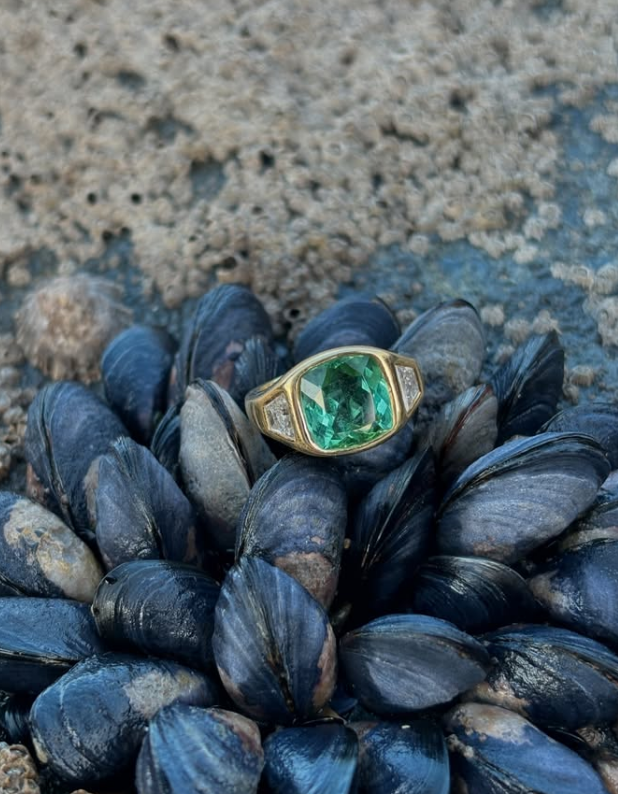 Lifestyle shot of 18k yellow gold bridal ring featuring 5ct green cushion-cut Tourmaline and 0.50ct trapezoid diamonds