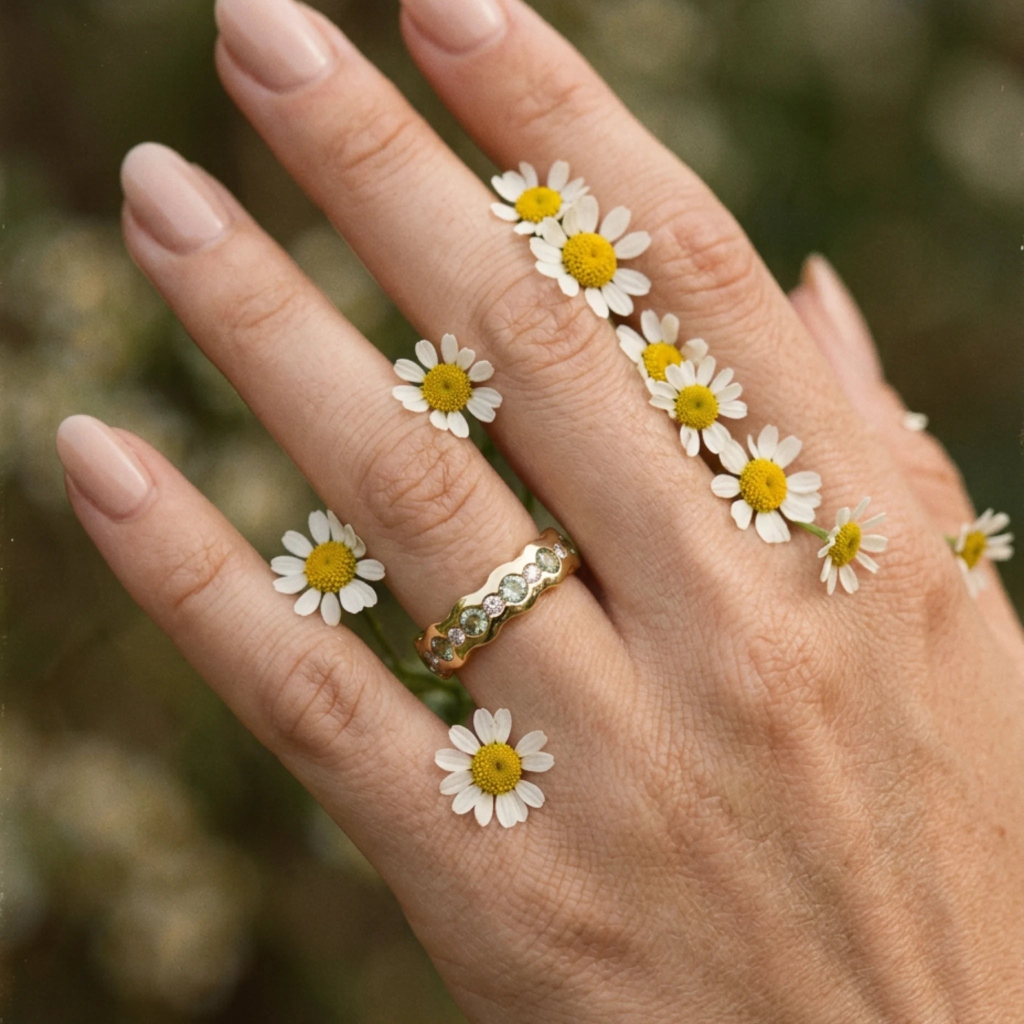 Close-up of green sapphire and diamond eternity ring in solid 18k yellow gold with wavy band, vivid green sapphires and round-cut white diamonds