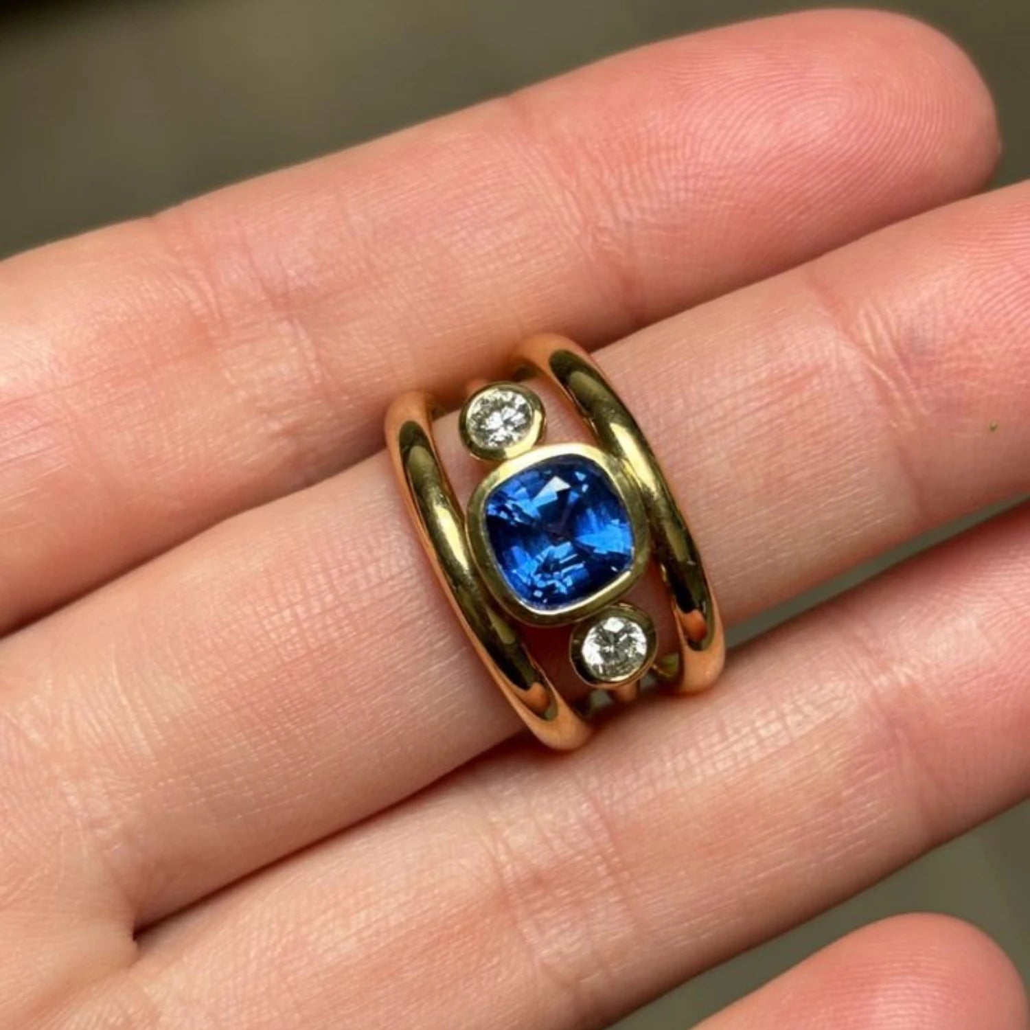 Close-up of Les Trois Vallées sapphire and diamond ring showing 2.35ct Royal Blue Sri Lankan sapphire with 0.50ct round diamonds in 18k yellow gold