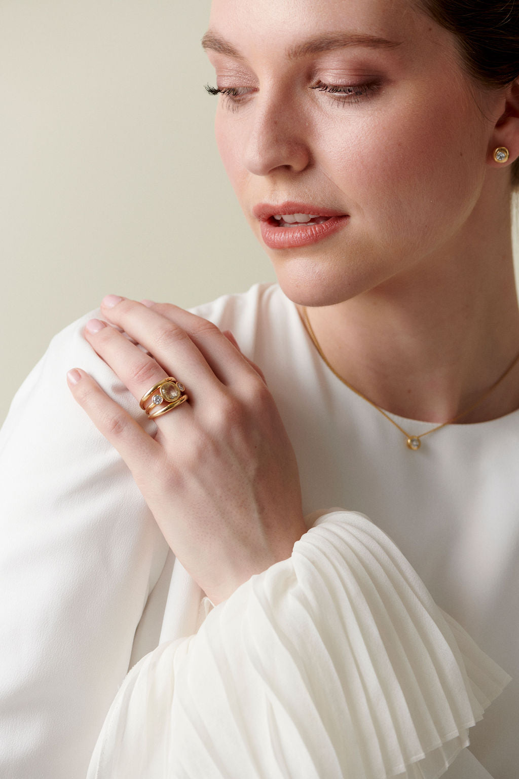 Model wearing 18k yellow gold ring with 3.08ct no-heat Sri Lankan yellow sapphire and white diamonds, styled with diamond necklace & stud earrings